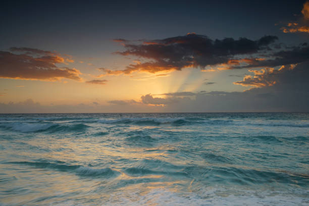 A tranquil seascape at sunset with gentle waves splashing in the distance