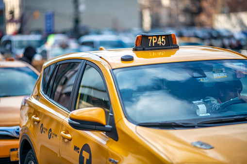 People ride yellow cabs in Midtown Manhattan in New York. As of 2012 there were 13,237 yellow taxi cabs registered in New York City.