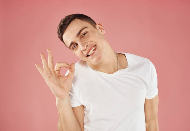 istock Cute man and white t-shirt hand gesture emotions pink background 2079284329