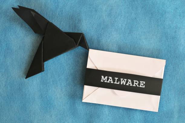 Black raven paper origami carrying white letter envelope with word Malware. Receiving malware attack email concept.