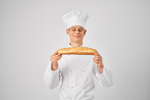 male chef with a baguette in his hands fresh product professional work. High quality photo
