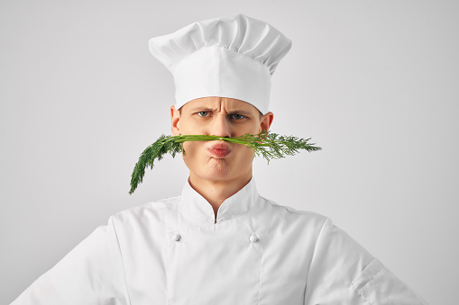 man chef's uniform nose green kitchen restaurant professional. High quality photo