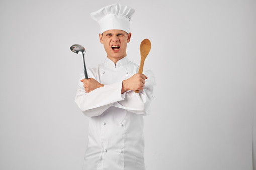 man in chef's uniform with kitchen utensils preparing food Professional. High quality photo