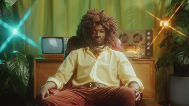 Portrait of Confident Black Man In Stylish Outfit Posing in Retro Studio