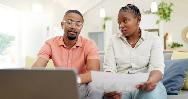 istock Finance, documents and couple with laptop on sofa with bills, paperwork and insurance budget. Financial planning, mortgage and black man and woman on computer for pension, tax payment or investment 2079428644