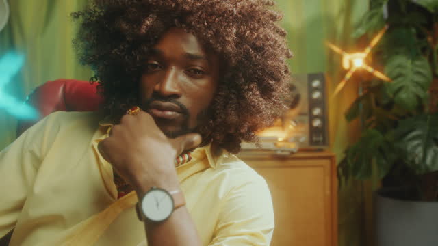 Portrait of Handsome Black Man in Curly Hair Wig Posing in Retro Studio