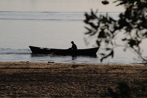 fisherman crossing the Paraná River in his canoe