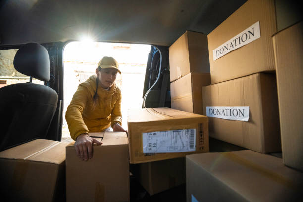 istock Female courier loads donation parcels for delivery. 2079455998