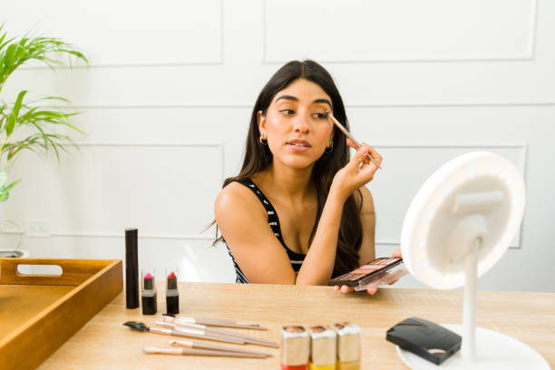 istock Young woman applying make-up at vanity table 2079467560