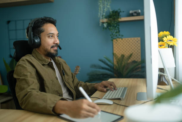 istock Asian man with headset having video call on  computer in his home office 2079518335