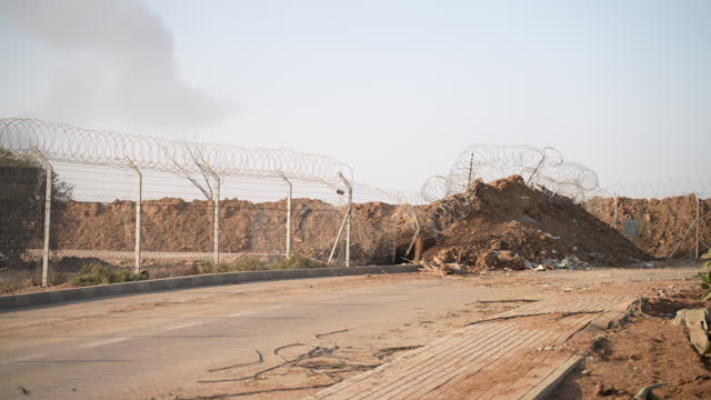 Barbed Wire Fence Enclosure At Detention Center In Gaza, Palestine. pan right shot