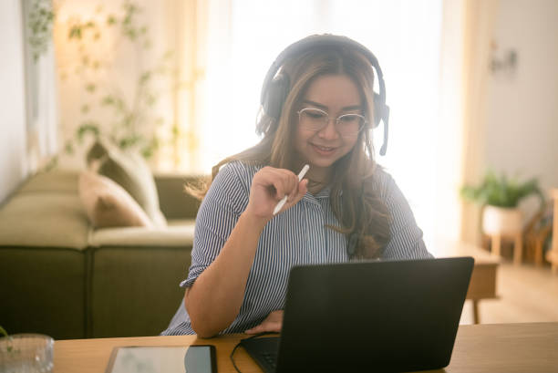 istock Cheerful woman sitting in living room using laptop computer for work. 2079525214
