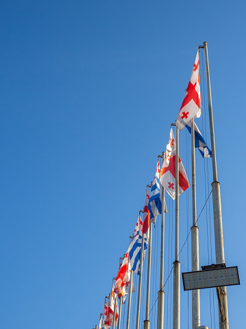 Flags of Georgia and Adjara on flagpoles. Many flags against the sky. State symbols