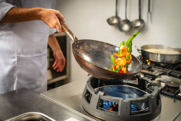 istock Cook stir frying vegetables and prawns in a wok 2079553753