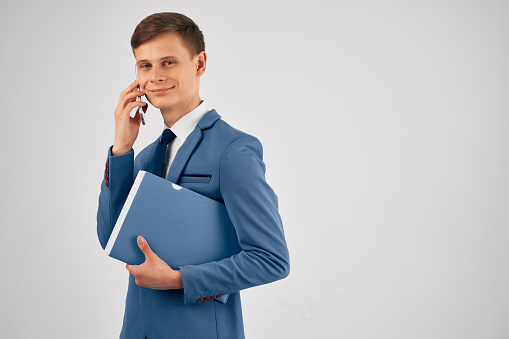 business man with blue folder talking on the phone manager professional. High quality photo
