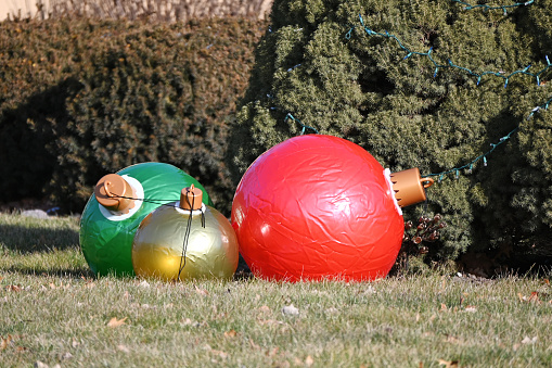 Three white lanterns in the form of a ball of different sizes in the park on the grass