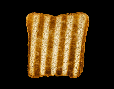 Burnt bread, Black toasted piece of bread on a black background