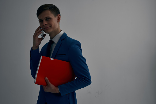 Leader in black jacket looking through document and waiting for a meeting with business partner at the office