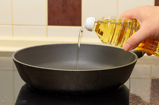 Sunflower oil is poured into the frying pan.