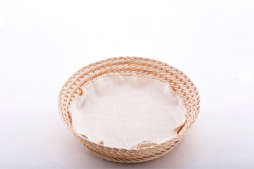 Empty wicker basket with cloth napkin, isolated on white background with space for text