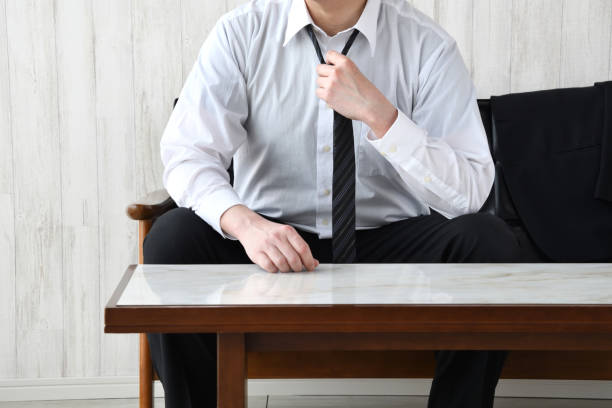 Business man taking off tie in living room