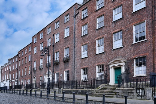 Row of 18th century brick townhouses on cobblestoned street in Dublin