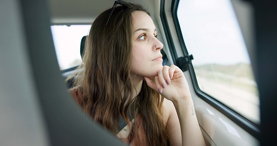 Thinking, driving and young woman in a car on a road trip for adventure, journey or vacation. Idea, reflection and female person from Australia with memory by window in vehicle for holiday transport.
