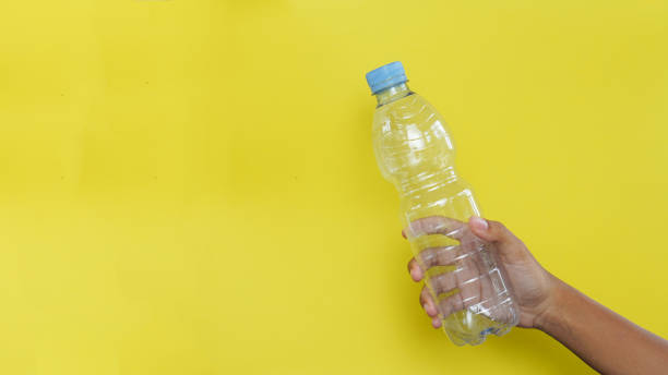 Hand hold plastic bottle  on yellow background