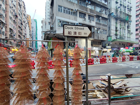 Incense coils under the sign of Dock street, a street in Hung Hom, an area of Kowloon, in Hong Kong, administratively part of the Kowloon City District.
