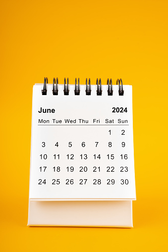 White clean June desk calendar for 2024 year on yellow background.