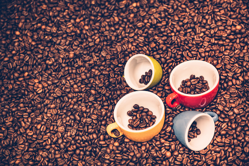 Coffee cups on a roasted coffee beans ground