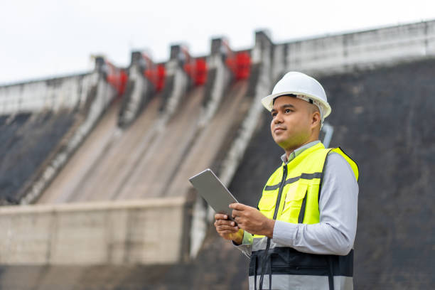 istock Professional asian maintenance engineer man with safety helmet in construction site dam with hydroelectric power plant and irrigation. Manager engineer man working with tablet at project big building. 2079942401