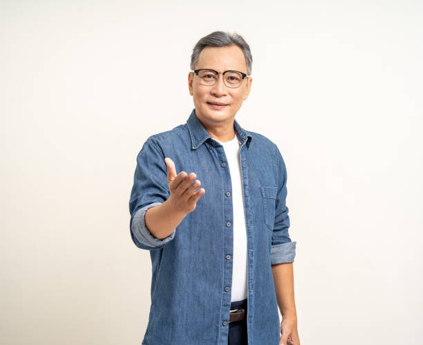Handsome asian mature old man standing hands palm up on isolated white background. Happy Portrait of cheerful smiling senior asian man looking at camera. Mature People and lifestyle