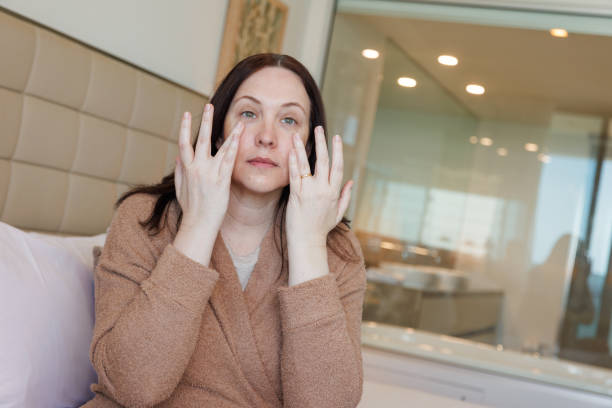 istock Woman in bath robe applying face cream 2079961097