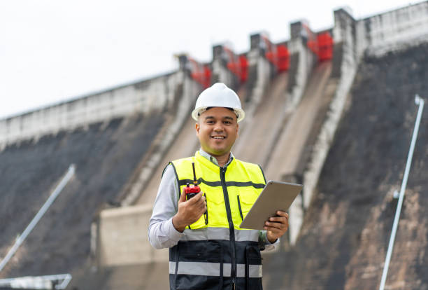istock Professional asian maintenance engineer man with safety helmet in construction site dam with hydroelectric power plant and irrigation. Manager engineer man working with tablet at project big building. 2079986919