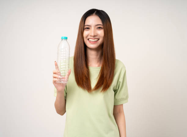istock Young asian beautiful woman holding plastic of bottle assume Garbage sorting before throwing them into the bin. Activist environmental woman in green shirt with recycle and sustainability concept. 2079995249