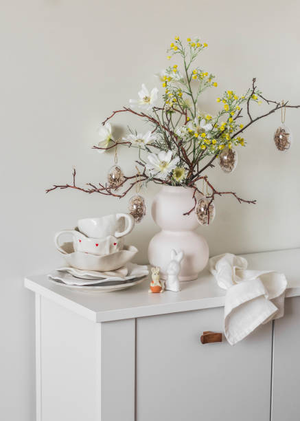 istock Ceramic white tableware, Easter decor, Easter bouquet on a white wooden chest of drawers in the living room. Holiday mood 2080032822