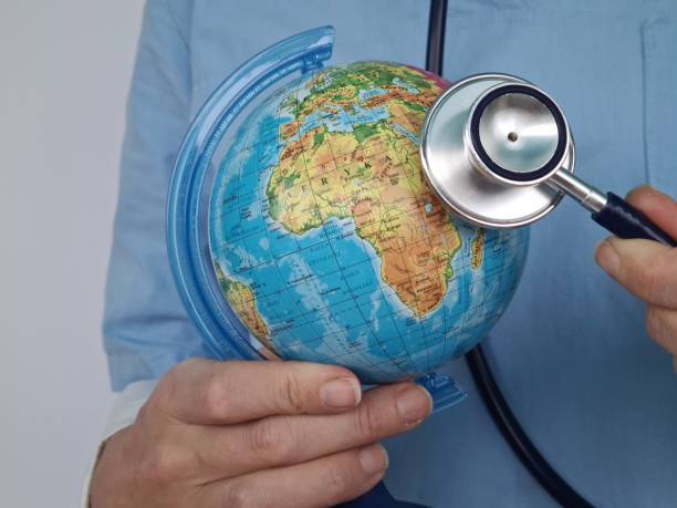 istock Person Holding Stethoscope in Front of Globe 2080086938