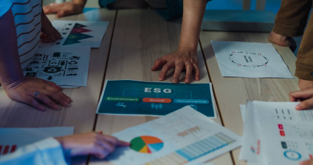 istock Close-up of team hands analyzing Environmental Social Governance (ESG) reports, reinforcing responsible business strategies in an office setting. ESG sustainable business office night. 2080091080