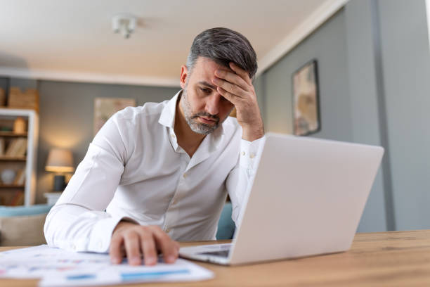 istock Handsome man working on laptop. Business man busy working on laptop computer at office. Businessman sitting at bright modern work station and typing on laptop 2080175531