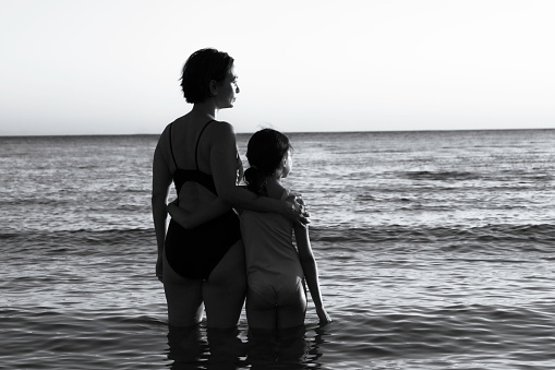 Mother and daughter holding hands at sea. Aegean Sea.