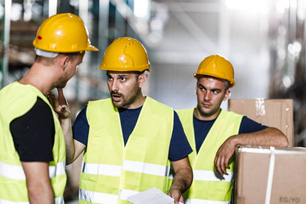 istock Frustrated manual workers arguing with their colleague in a warehouse. 2080183293