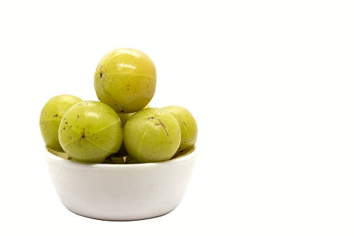 Indian Gooseberry Fruit or Amla Fruit in a White Bowl Isolated on White Background with Copy Space, Also Known as Emblica Myrobalan or Phyllanthus Emblica