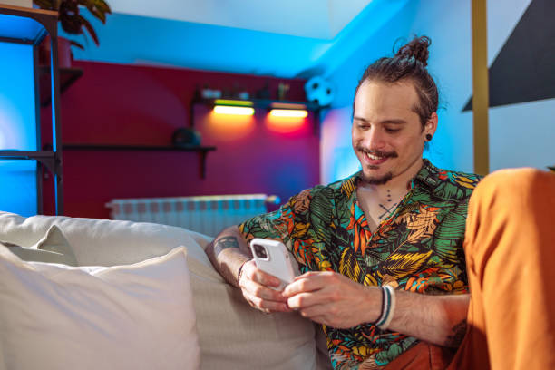 istock A smiling Latin-American man using a phone in the living room 2080213973