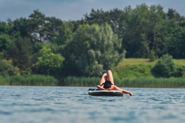 istock woman in swimming suit sunbathing on supboard 2080233256