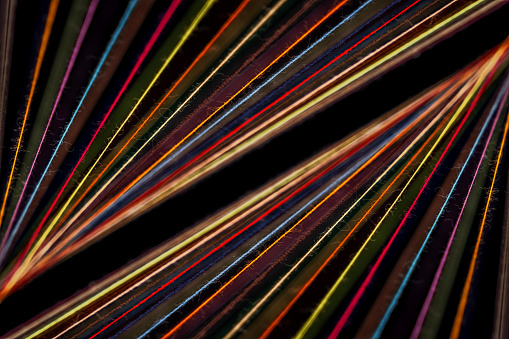 Converging Multi-colored Sewing Thread on a black background