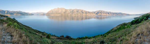 istock Panoramic vista of Lake Hawea in Otago's Southern Alps with mirror-like reflection, rugged mountains, and alpine beauty on Sunset 2080244809