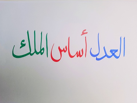 Justice is the foundation of kingship, written in handwritten Arabic script on a white background. The beauty of handwritten Arabic calligraphy, Arabic wisdom