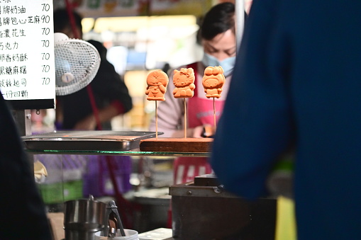 This photo shows a close-up view of a vendor selling Taiwanese sponge cakes at a stall in Ningxia Night Market.