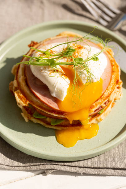 istock Breakfast of cheese waffles with ham and poached egg 2080333083